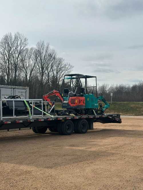 an image hauling small back ho's