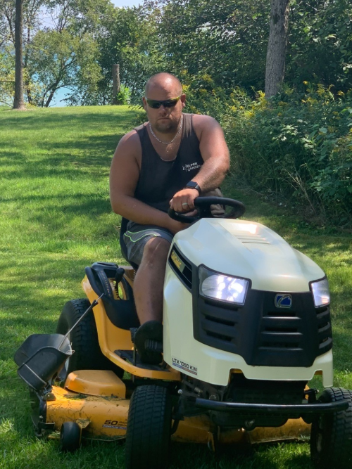 A picture of a Aaron on riding lawnmower